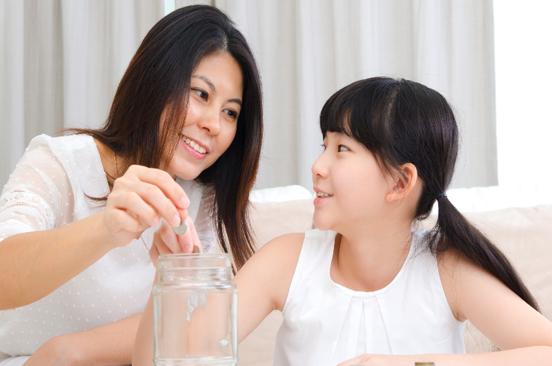 Mother teaching girl saving