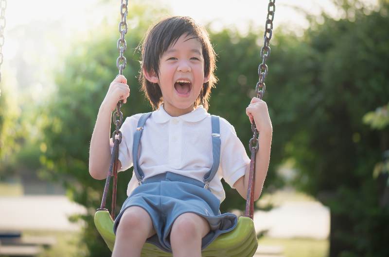 cute-asian-child-having-fun-on-swing-in-the-park