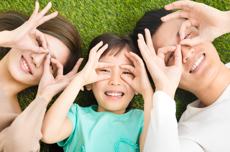top-view-of-happy-young-family-lying-on-the-grass